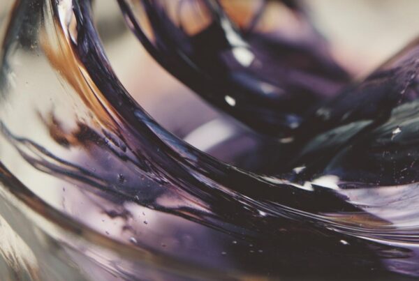 Swirling, glossy liquid in close-up detail evokes the visual texture of a lean drink.