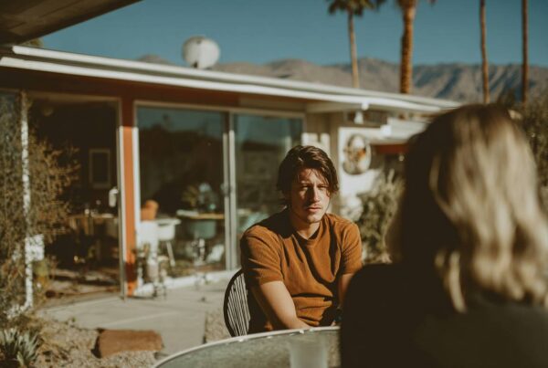 A young adult talking with someone outside in Palm Springs, illustrating a conversation about what are track marks.